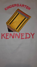 Close-up of Kindergarten embroidery with Light Gold pencil appliqué and the name Kennedy in pink thread on a white shirt