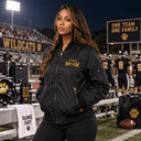 Woman wearing a black embroidered Football Mom team spirit jacket at a high school football game